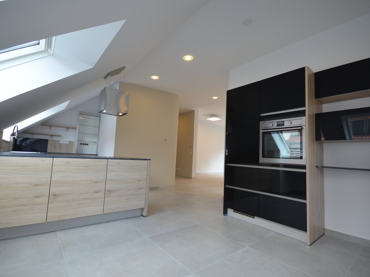 Moderne offene Küche mit Kochinsel und Dachschräge in der Penthouse-Wohnung im Stuttgarter Westend